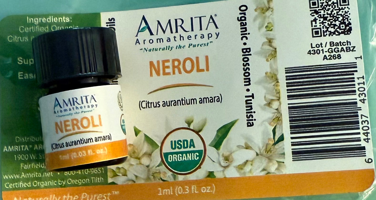 Amrita Aromatherapy 1 ml Neroli essential oil bottle with label on a green background