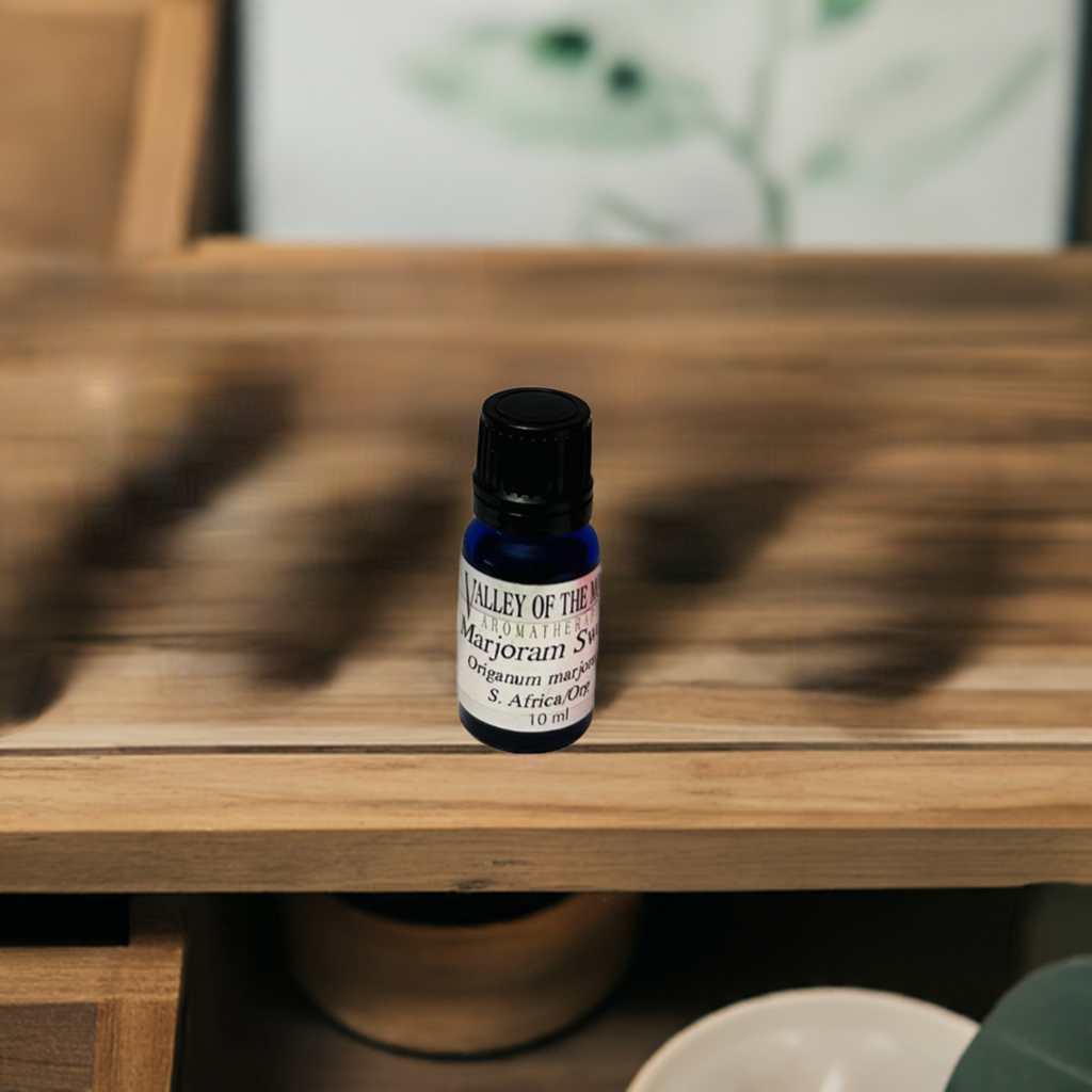 marjoram blue essential oil bottle on a wooden surface with valley of the moon aromatherapy labeling