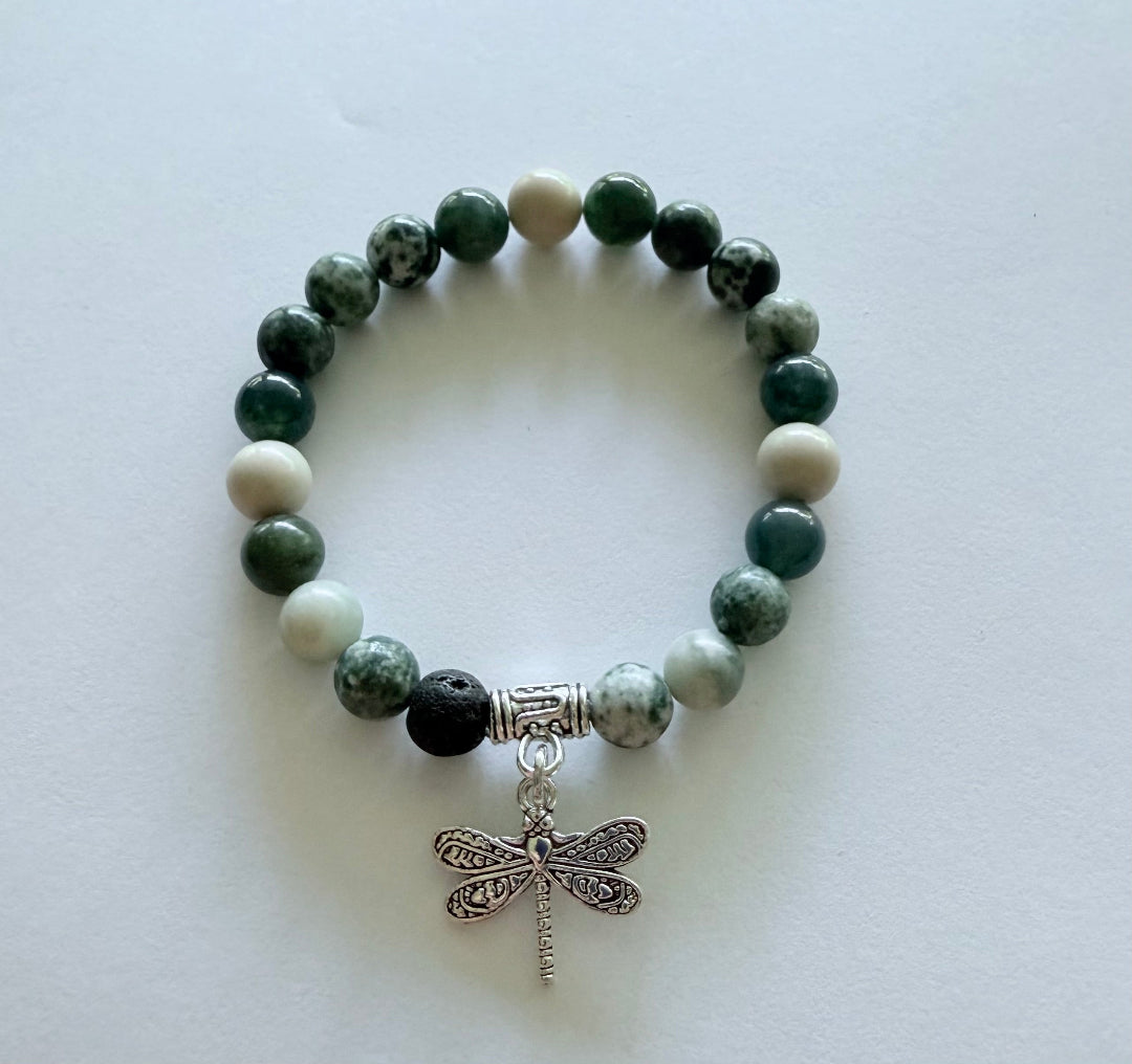 shades of green gemstone bracelet with a dragonfly charm on a white background