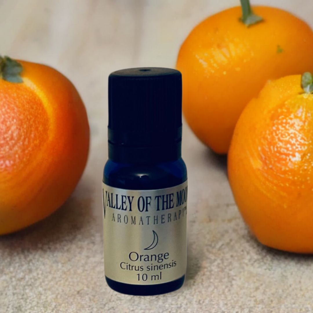 Bottle of Valley of the Moon Aromatherapy Orange oil with three oranges on a textured surface