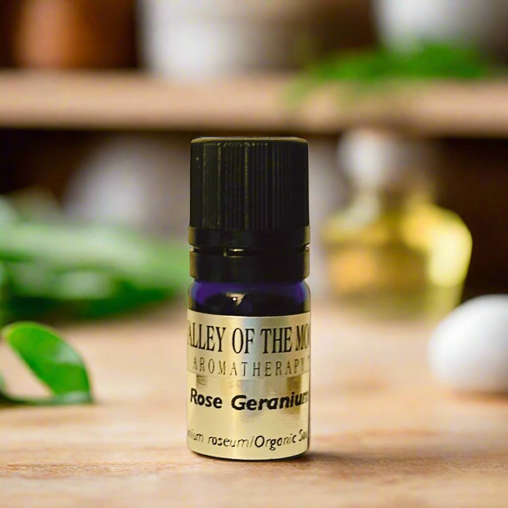 Small Bottle of Rose Geranium Organic Essential Oil on a wooden table top